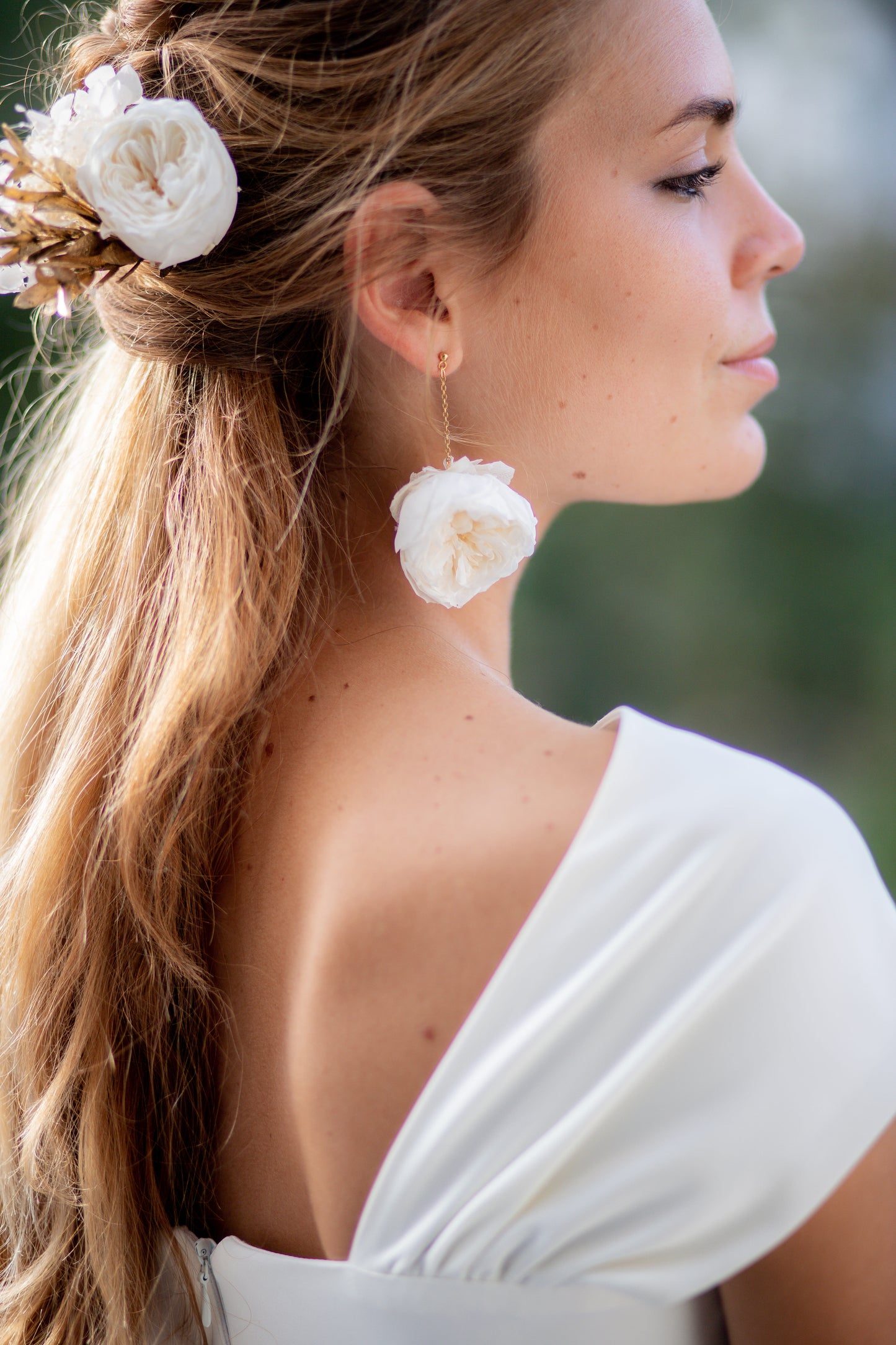 Boucles d’oreilles en fleurs stabilisées composée d'une chaine soutenant une rose blanche ,personnalisables pour oreilles percées ou à clips.