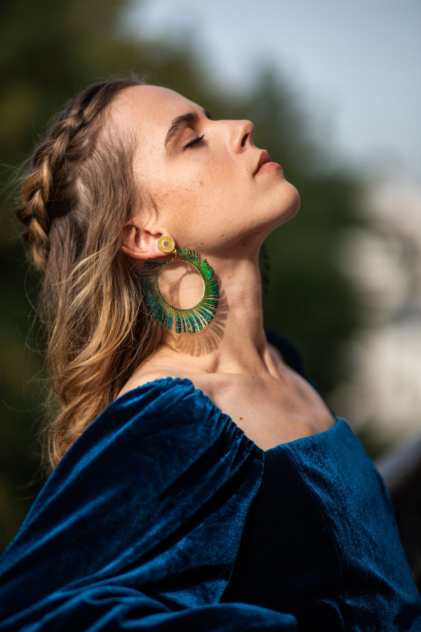 Boucles d’oreilles ornées d’une plume de paon autour d’une créole, personnalisables pour oreilles percées ou à clips.