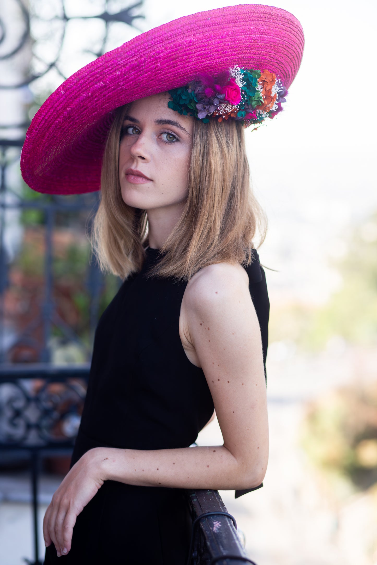 Capeline incurvée en paille colorée décorée de fleurs stabilisées en dessous