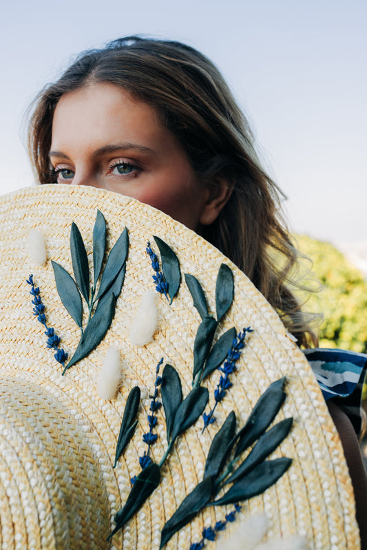 Capeline plate en paille nature décorée de feuilles d'olivier, de lavande et de fleurs stabilisées invitées